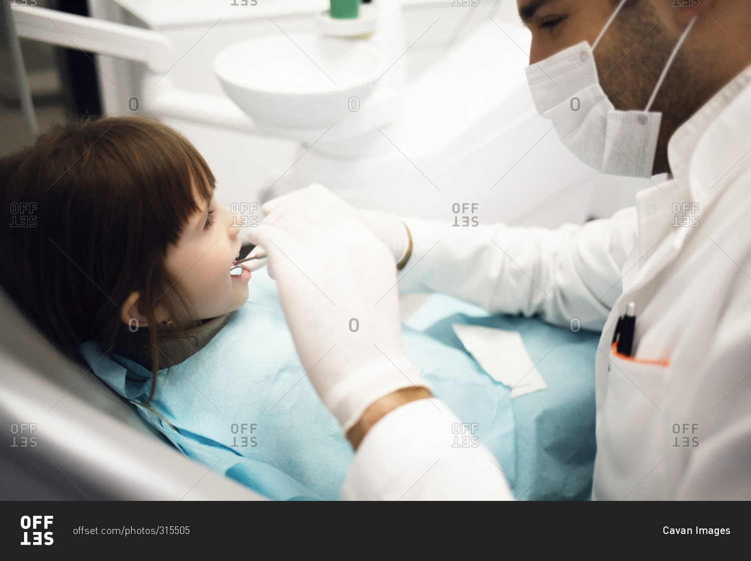 Dentist examining teeth of young girl