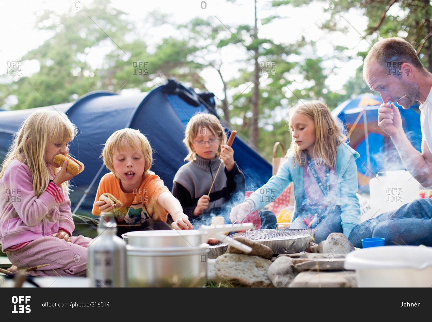 A family eating food outside a tent, Sweden