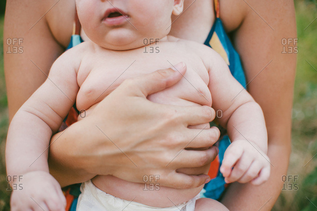 Bare chested baby in woman's arms