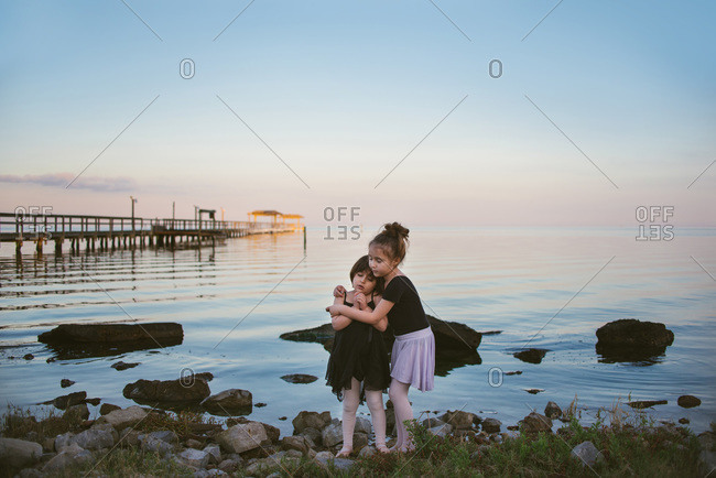 Girls hugging close on shore