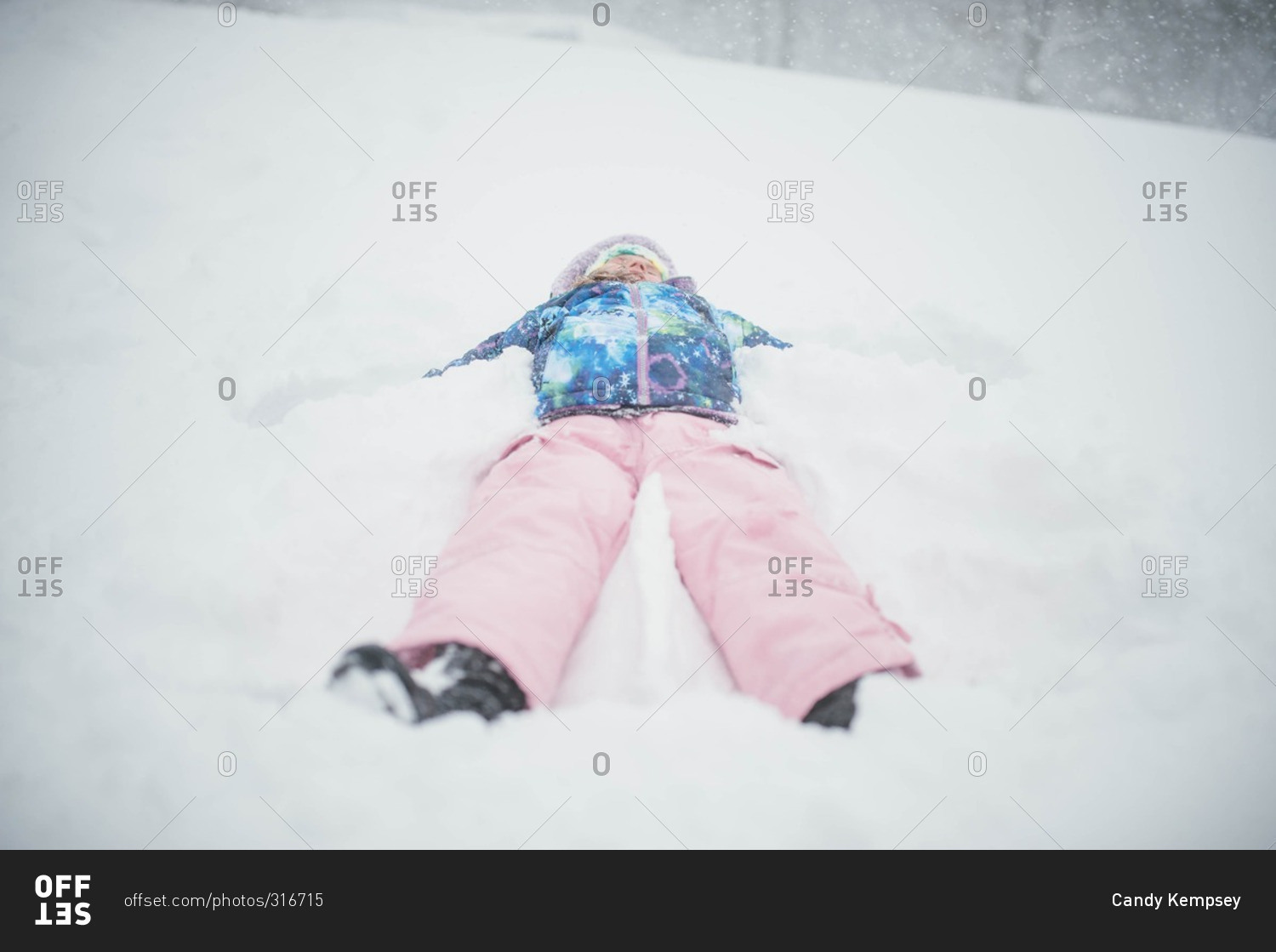 Young girl lying on her back in snow