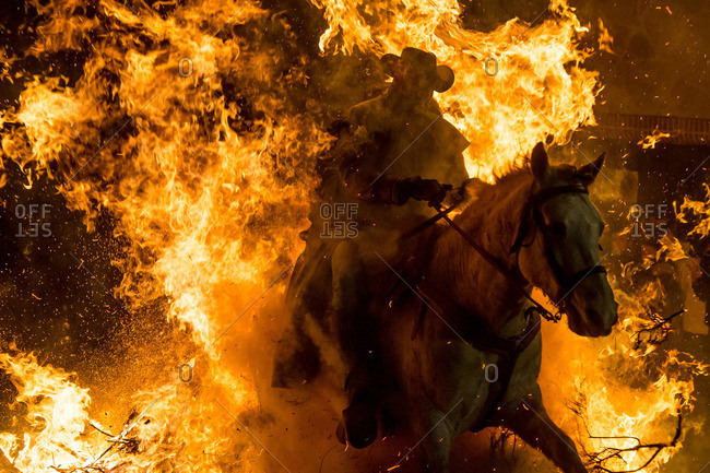 A horseman jumps over a bonfire in Avila, Spain during the religious festival Las Luminarias in honour of Saint Anthony