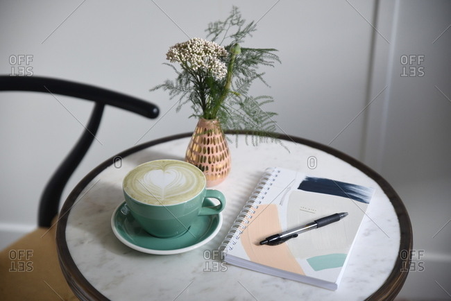 Fresh coffee and planner at empty cafe table