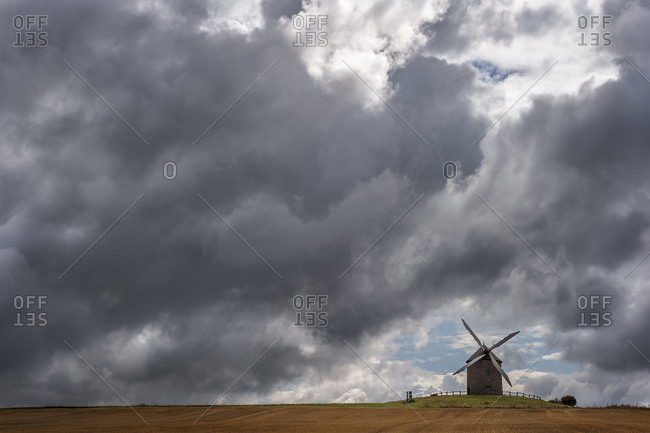 Picturesque windmill under a stormy sky in farmlands in Normandy,  France
