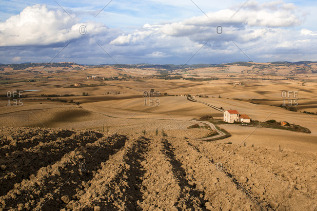 Furrowed expanses of farm fields in Val D'Orcia, Tuscany, Italy