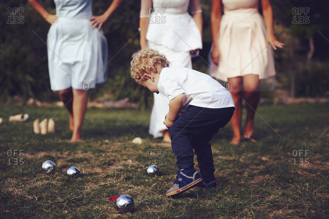 Little boy playing lawn bowls at a wedding reception
