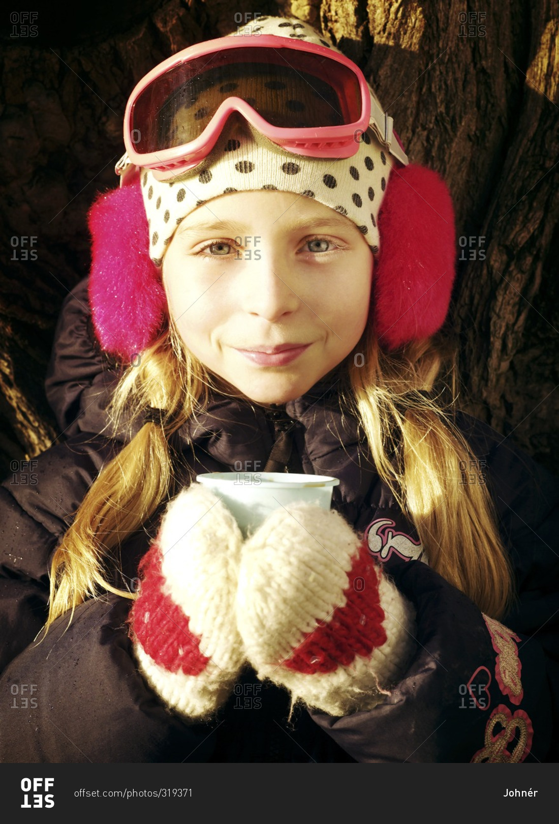 Portrait of girl wearing winter clothing holding cup