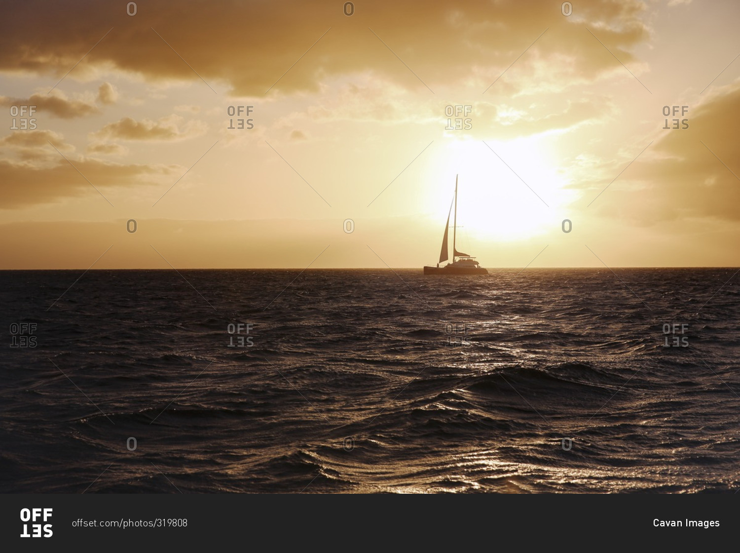 Silhouette of a sailboat on the ocean at sunset