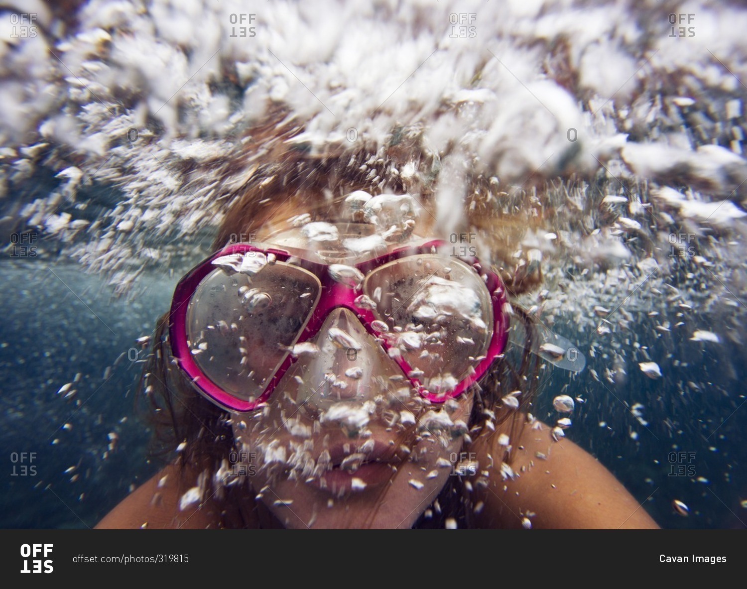 Young woman underwater blowing bubbles