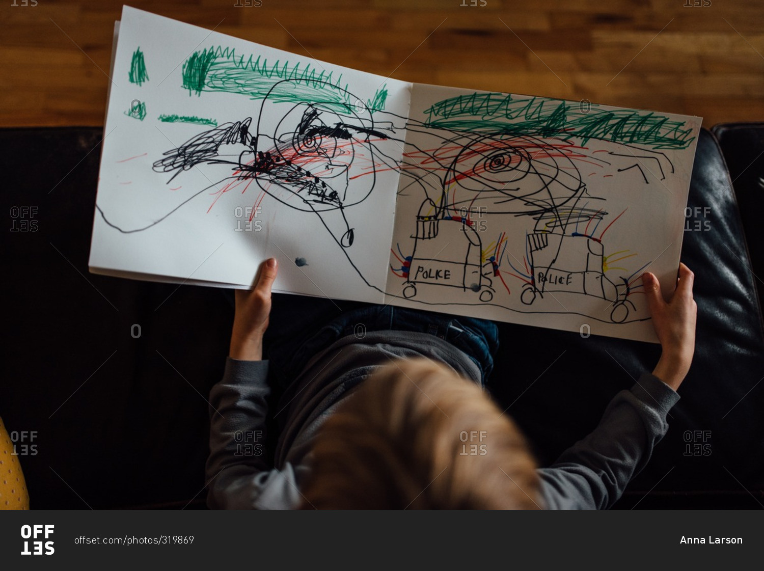 Overhead view of child looking at his drawing of police cars