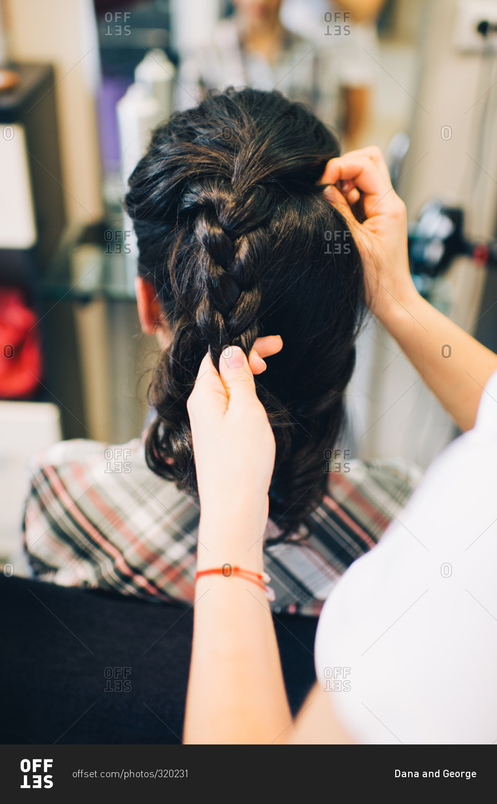 Stylist braiding woman's hair - Offset stock photo - OFFSET