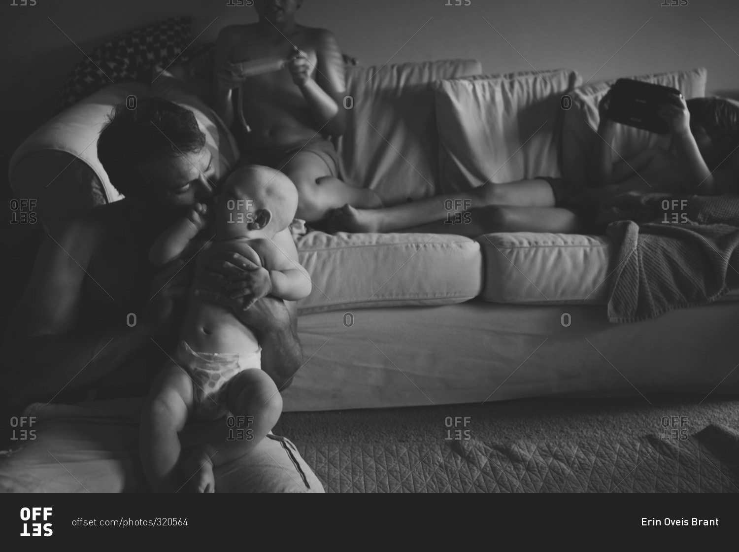 Father and children lounging around their living room in black and white