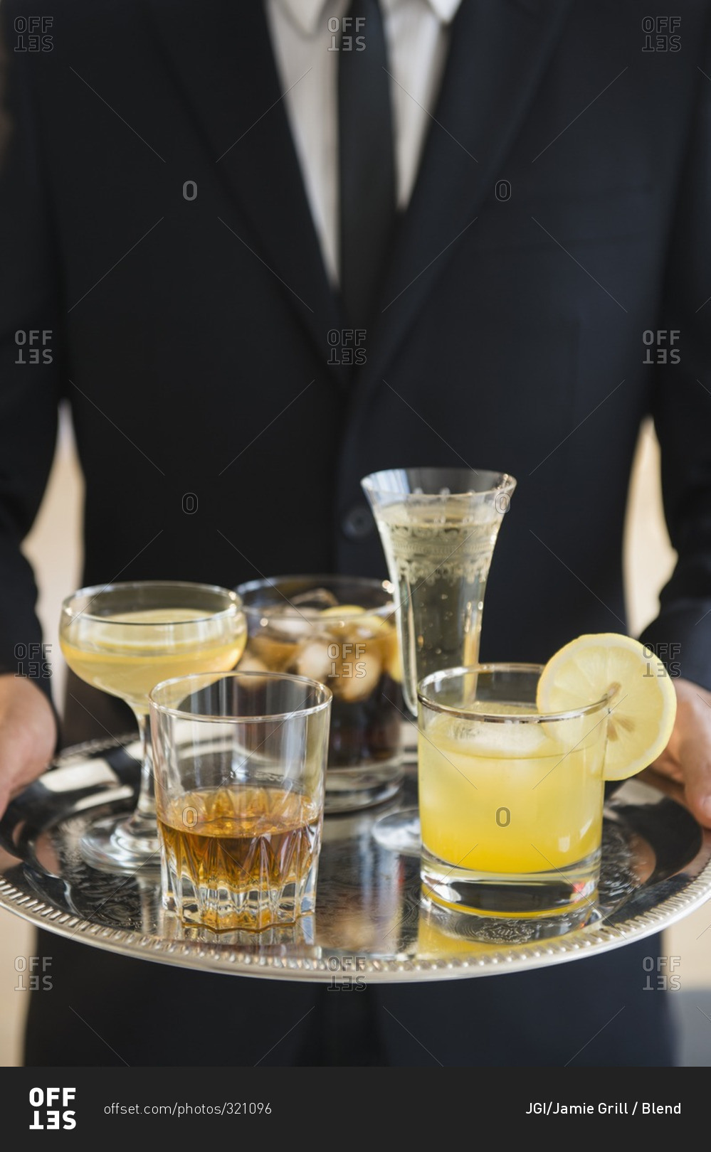 Close up of  waiter holding tray of drinks of yellow drinks