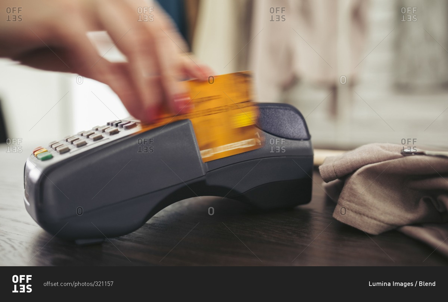 Woman swiping credit card through credit card reader
