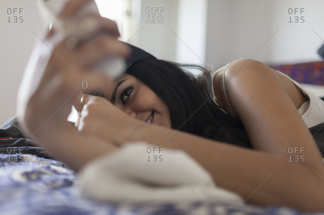 A hip woman on bed with phone