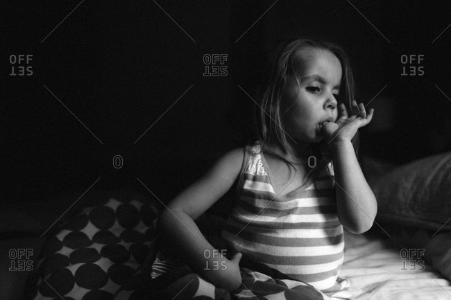 Little girl sucking her thumb in black and white