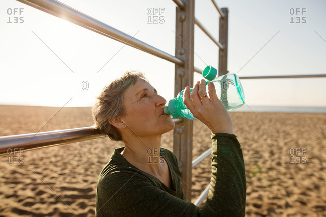 Woman hydrating on a beach