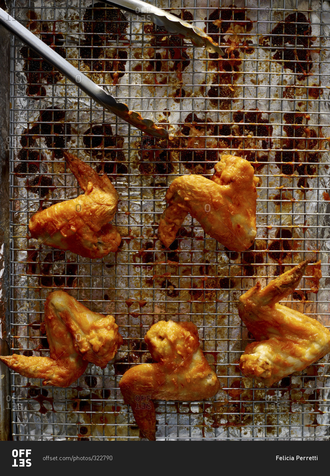 Overhead view of buffalo chicken wings on a wire cooking grate