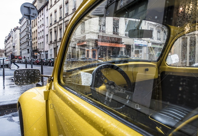 Lyon, France - December 31, 2015: View of city through window of a yellow classic car, Lyon, France