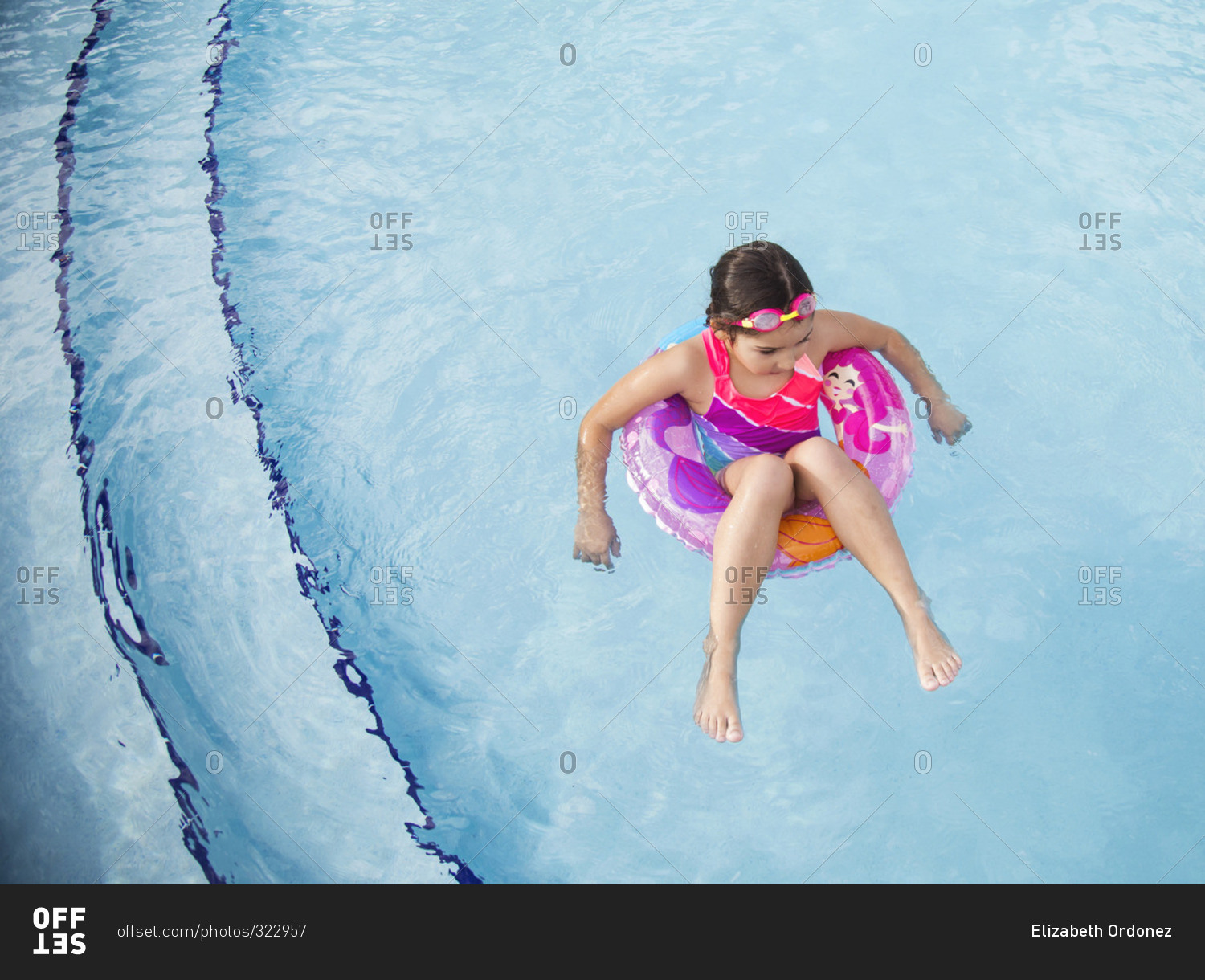 Little girl floating in an inner tube in a swimming pool in Miami, Florida