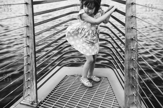 Girl standing at the front of a boat in a polka dot dress