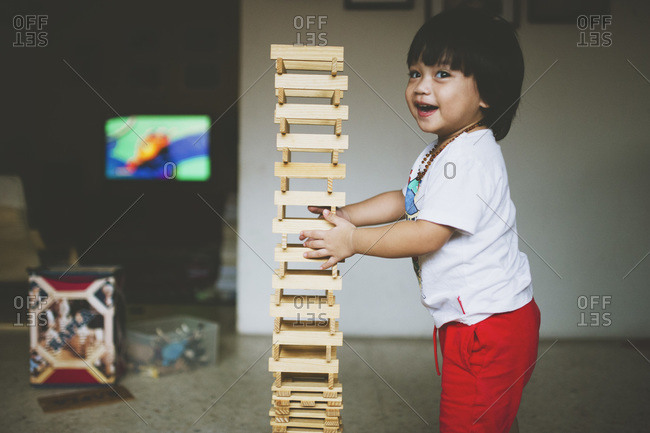 Boy touching wood block stack