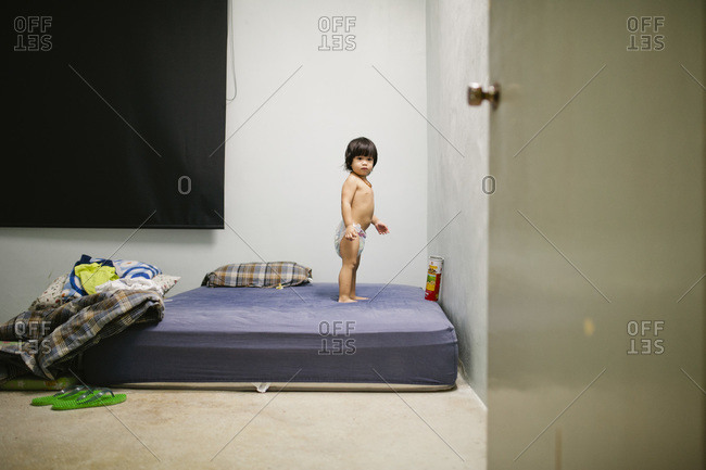 Boy standing on a mattress