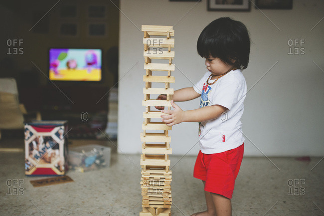 Boy touching a wood block stack