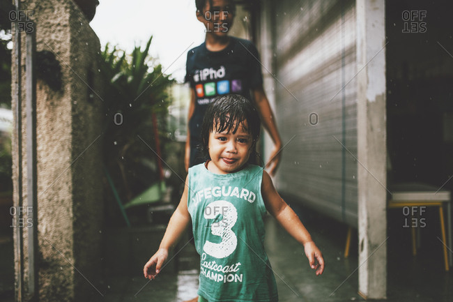 Two kids standing in the rain