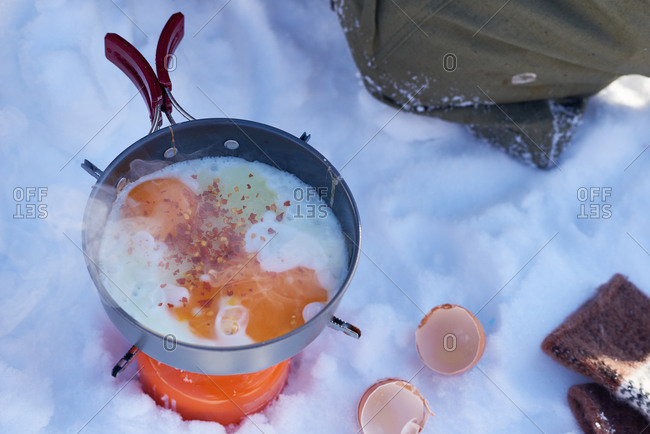 Eggs cooking over a single burner campstove