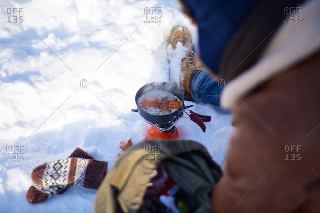 Man cooking eggs on a single burner campstove