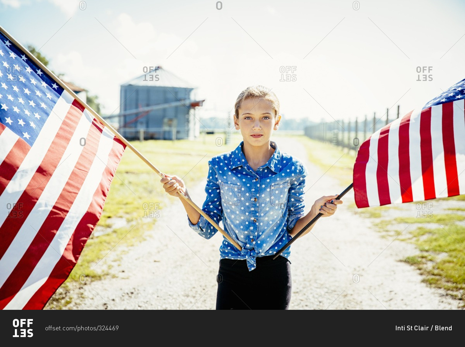 Girl waving American flags on farm