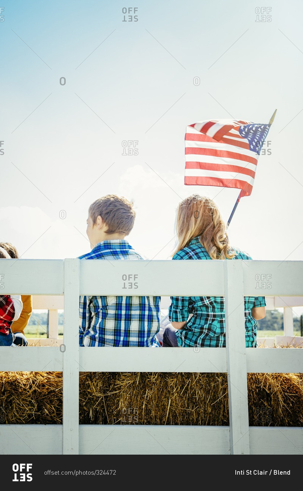 Children waving American flag on hay ride