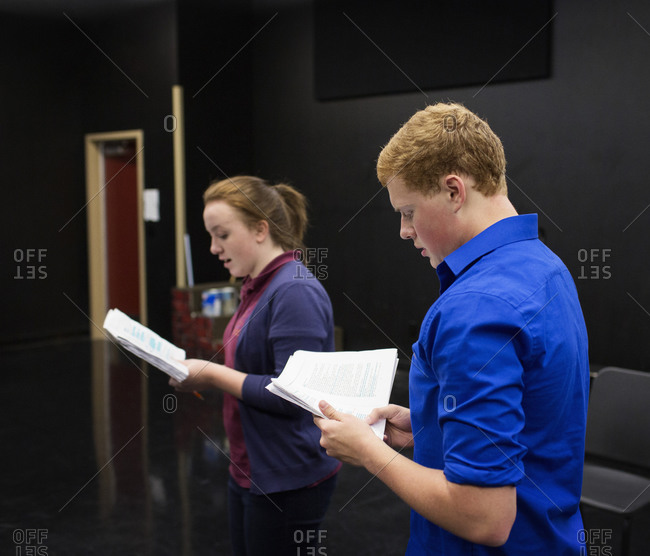 Students reading scripts in high school drama class
