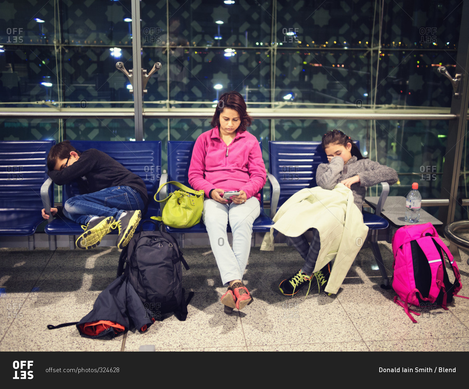 Mother and children relaxing in airport waiting area