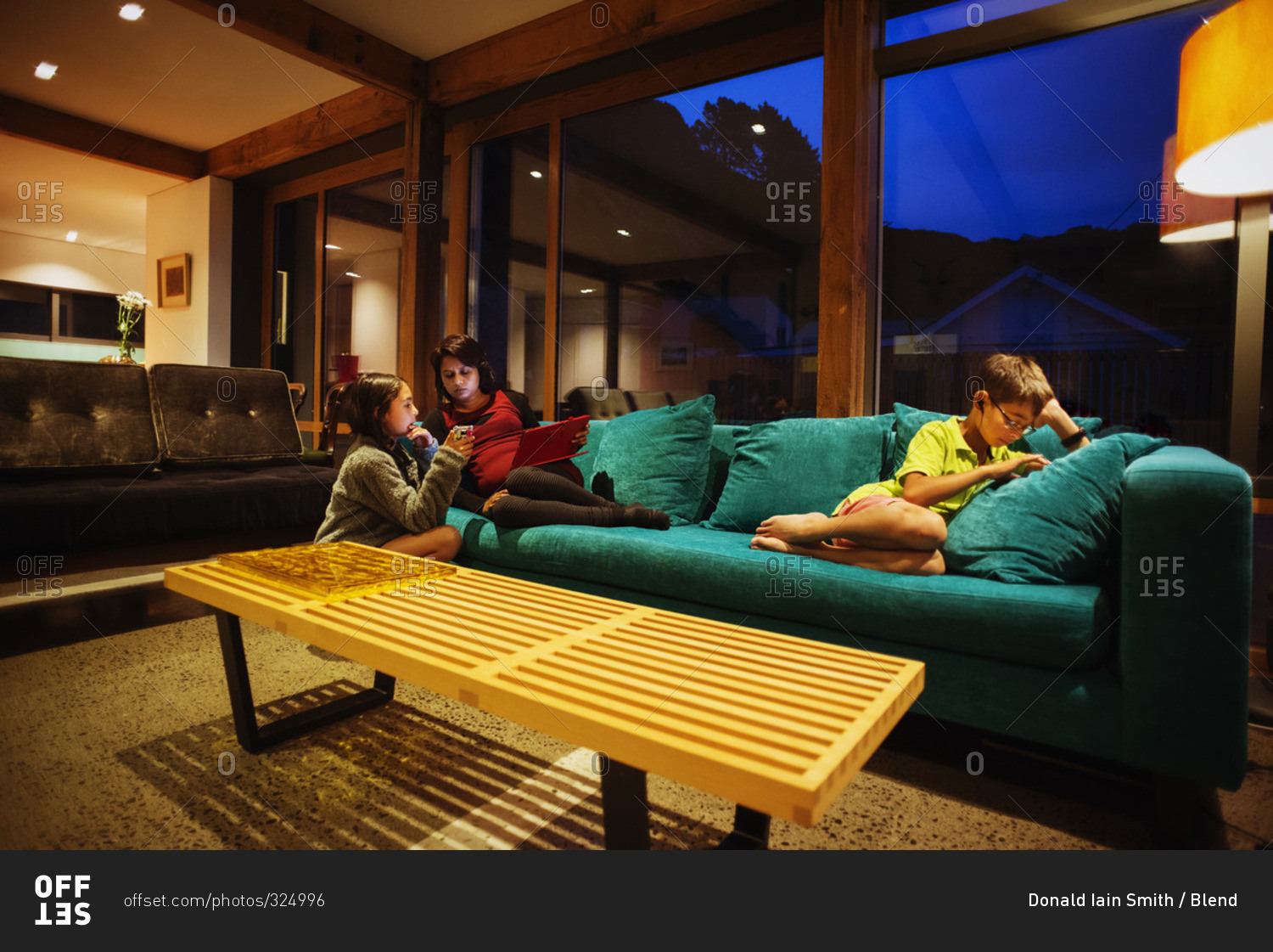 Mother and children relaxing together in modern living room