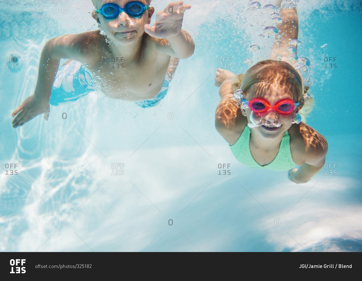 Children swimming underwater in pool