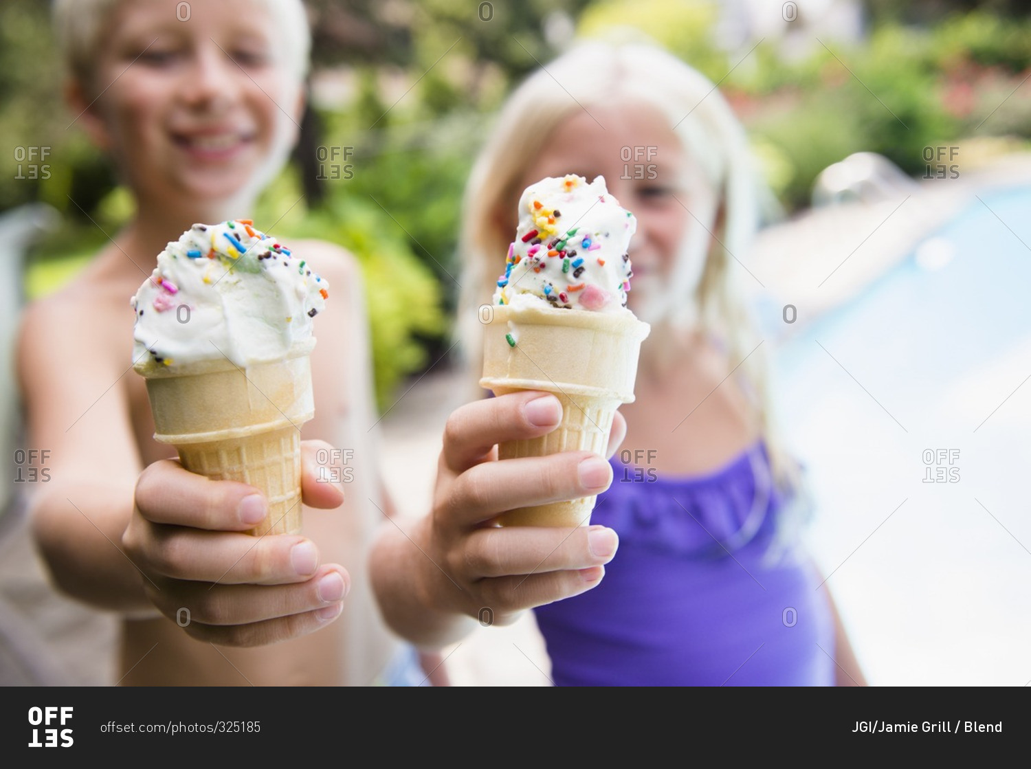 Children eating ice cream near swimming pool