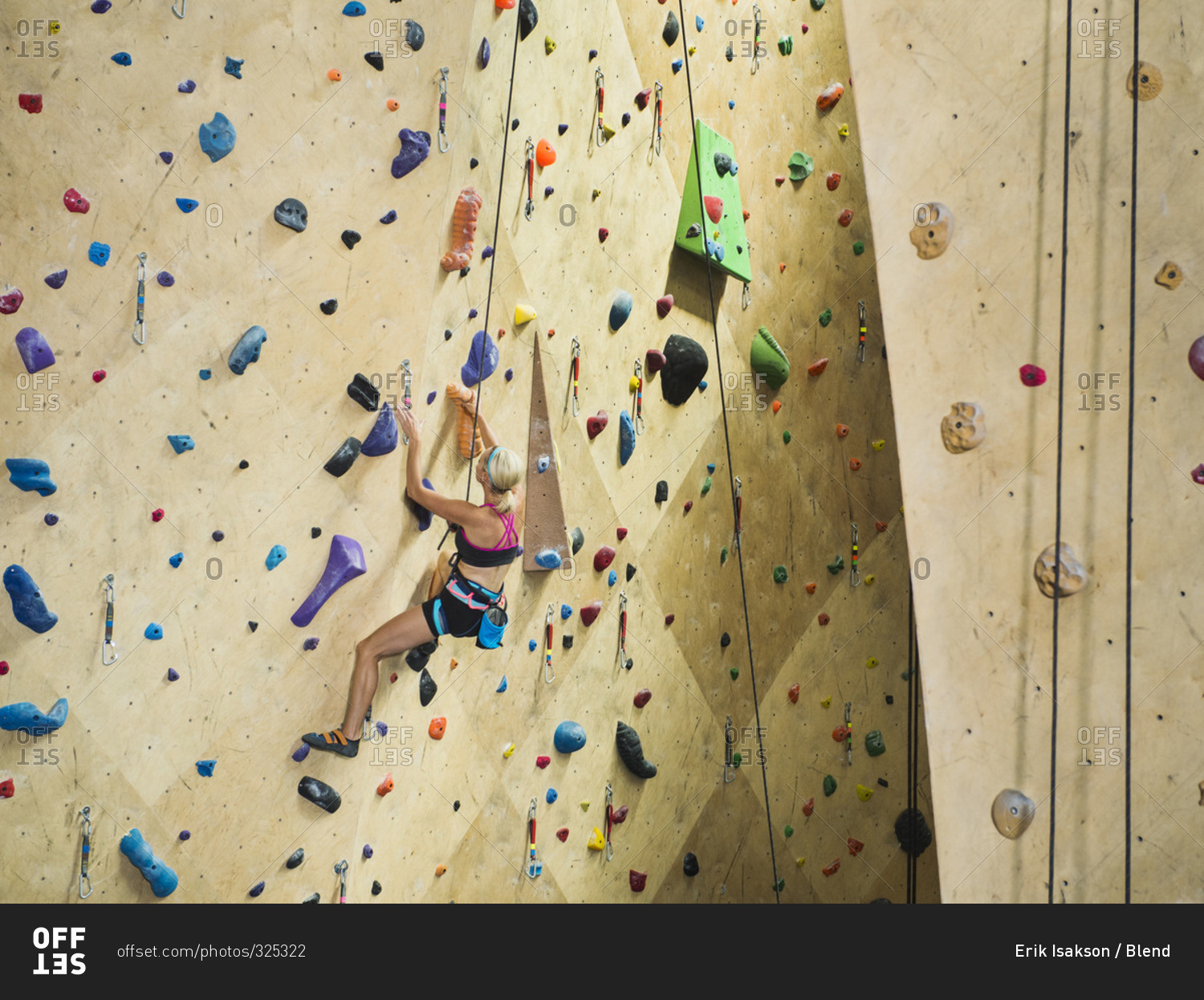 Woman climbing indoor rock wall
