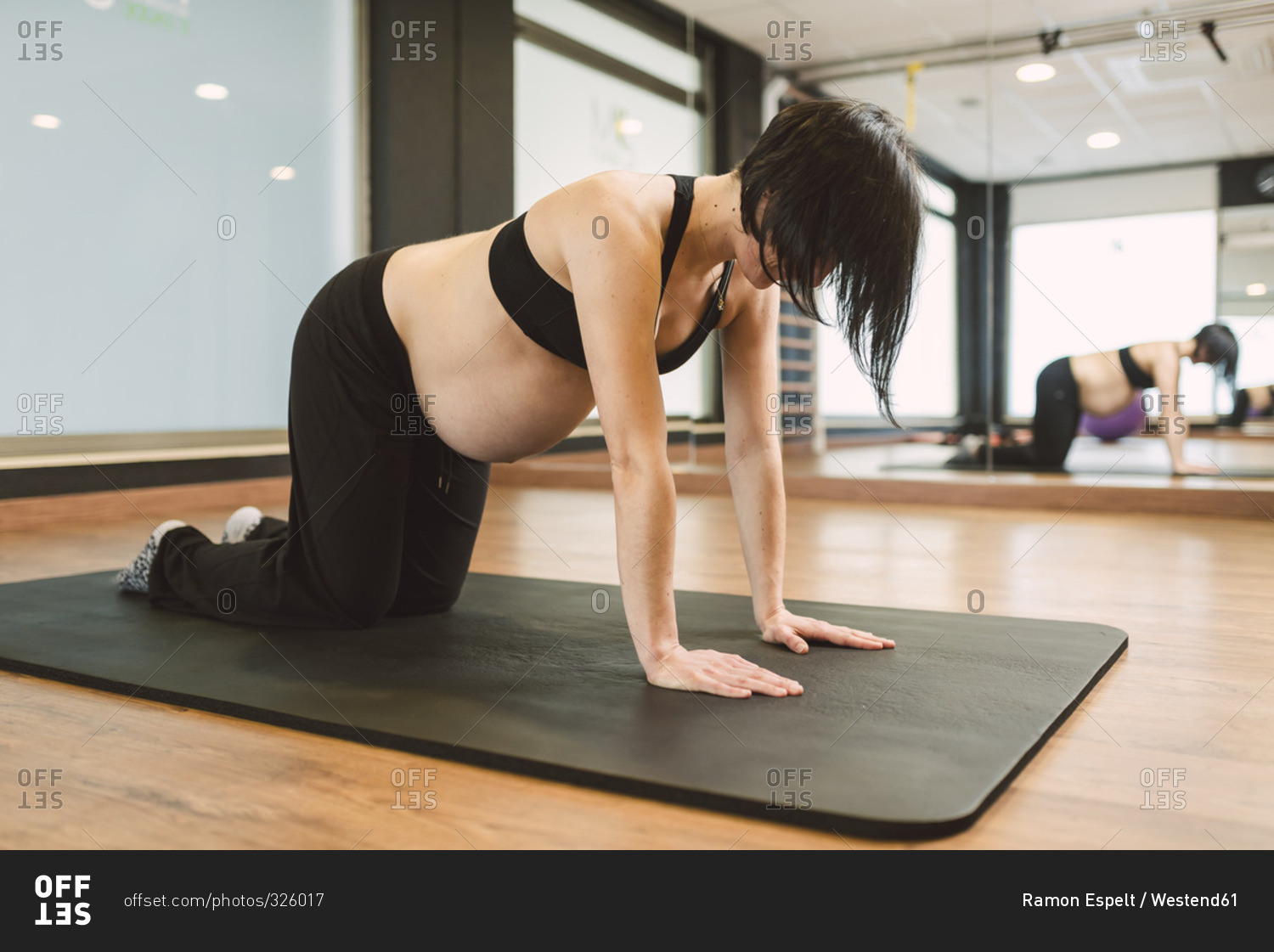 Pregnant woman doing exercises in a gym, all-fours position