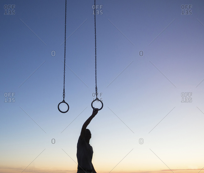 Silhouette of man reaching up for steady ring