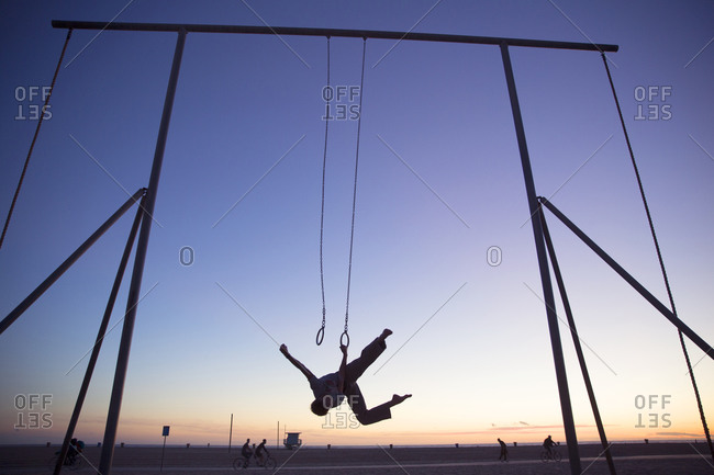 Silhouette of man working out on steady rings