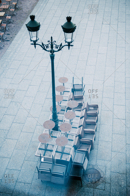 Tables and chairs arranged near a street lantern