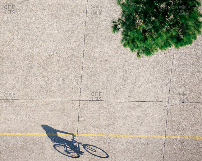 Shadow of a person riding bicycle on a sidewalk