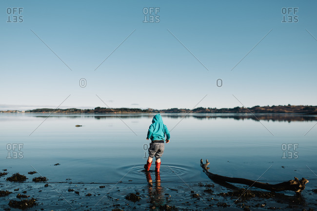 Kid in water in rain boots