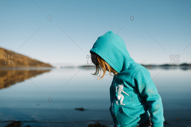 Kid in sweatshirt standing in lake