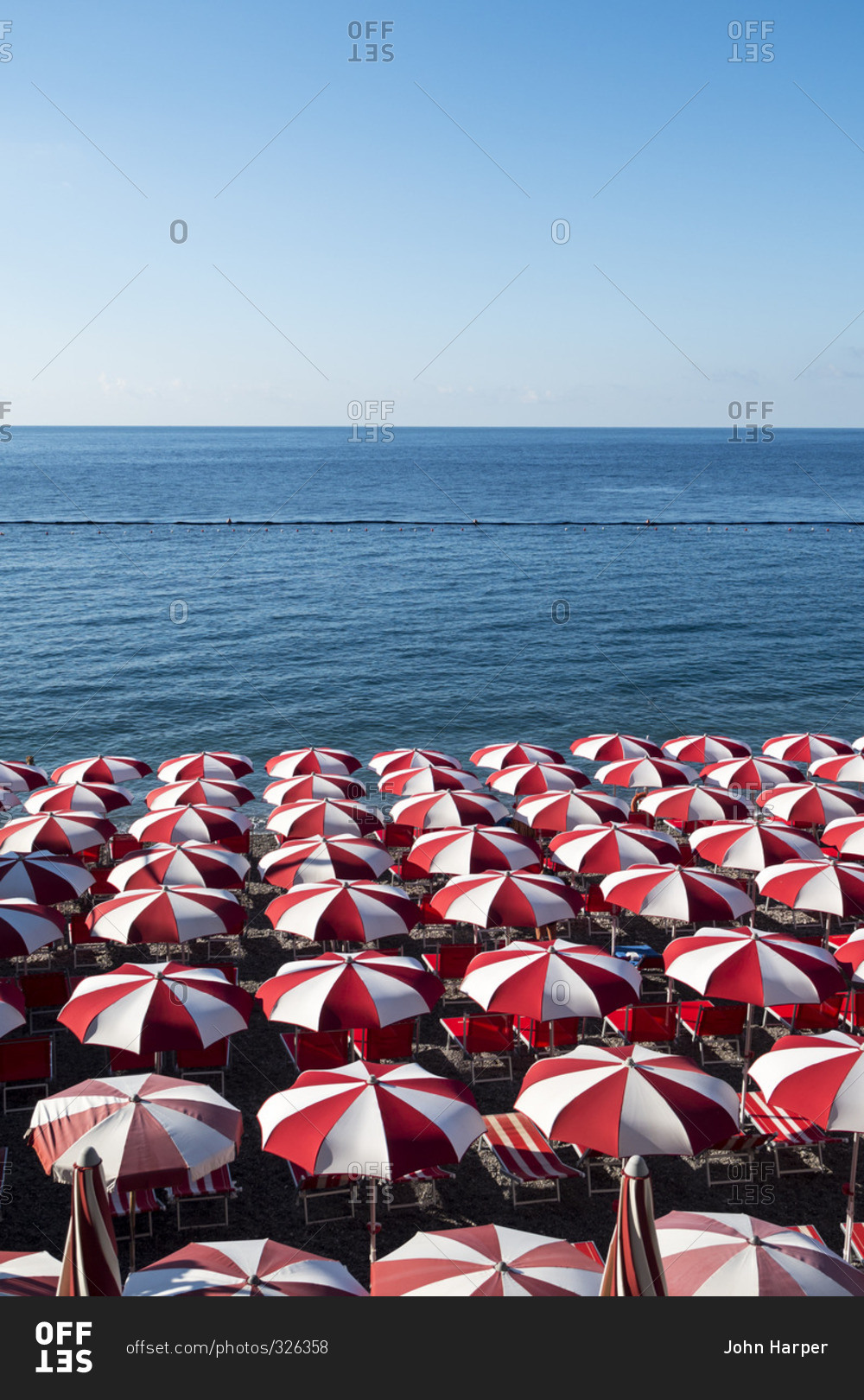Umbrellas on the beach in Italy stock photo - OFFSET