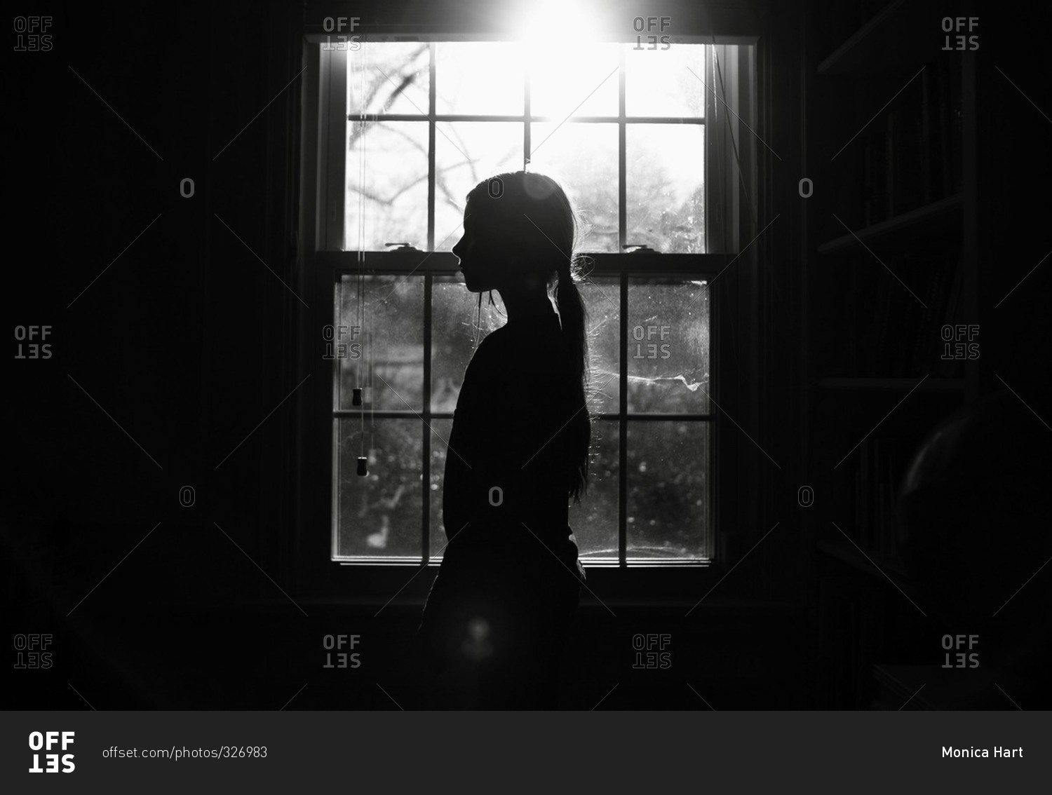 Silhouette of young girl by a window stock photo OFFSET