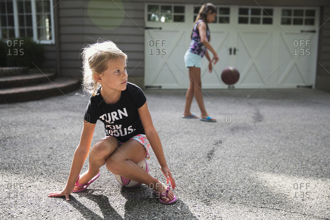 Two girls playing basketball in their driveway