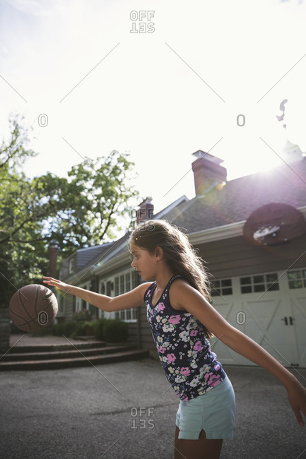 Girl playing basketball in her driveway